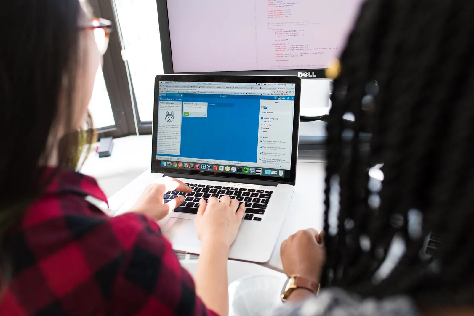 Person comparing two app builders on a laptop in a modern workspace