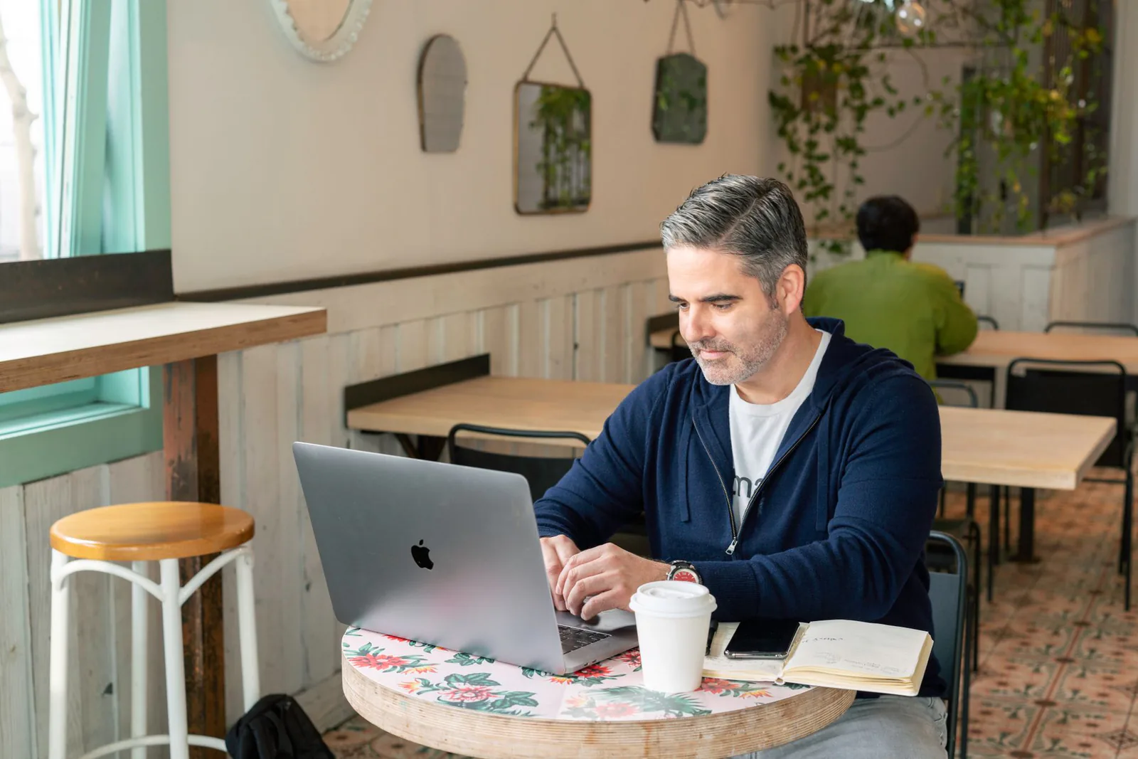 Small business owner working on laptop in a coffee shop