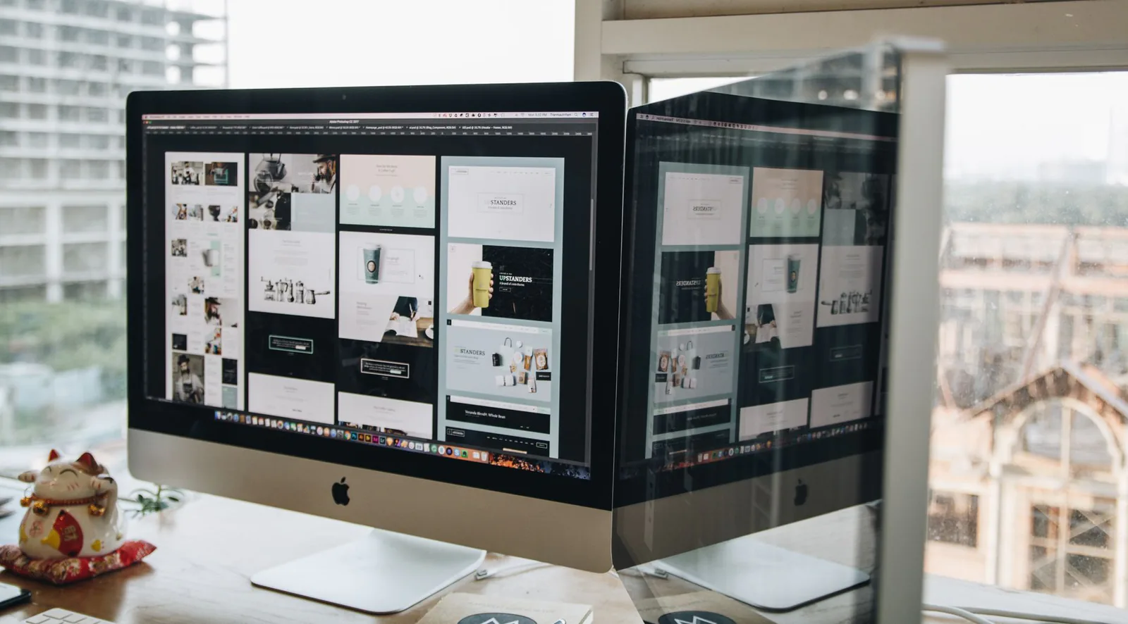 Dual monitors showing a detailed web design project