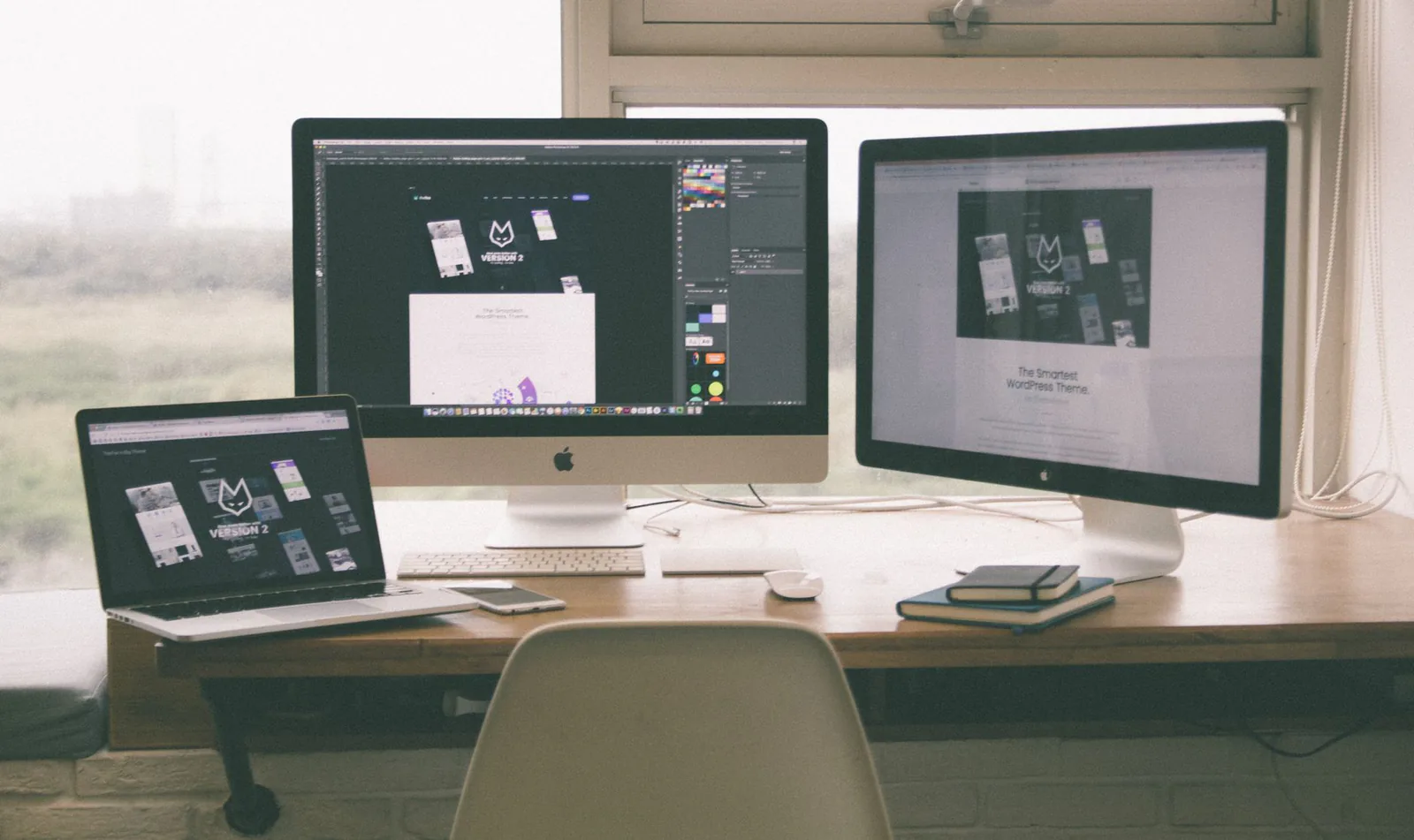 Stylish workspace with multiple monitors showing a web design project